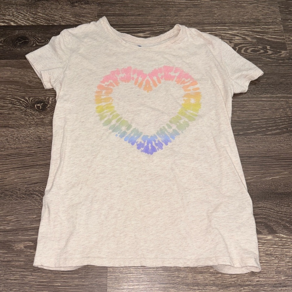 Girls oat colored shirt with a tie-dyed heart with pink, oranges, green, blue.
